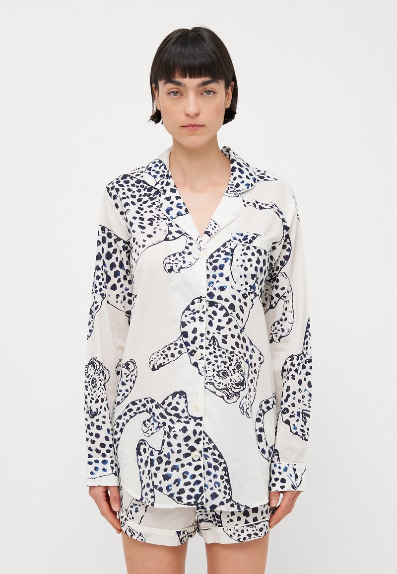 Langärmliges Schlafanzugshemd in Weiß mit navyblauem Leopardenmuster, ausgestattet mit einem Reverskragen, Knopfverschluss und passenden Shorts. Aus weichem, leichtem Material.