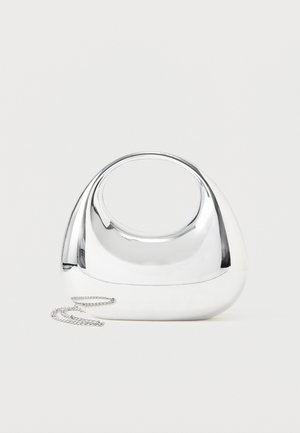 Λαμπερή, ασημί μεταλλική τσάντα χειρός με στρογγυλεμένο σχήμα, οβάλ λαβή κομμένη στο κέντρο και ασημένιο λουρί αλυσίδα σε μονόχρωμο ανοιχτό φόντο.