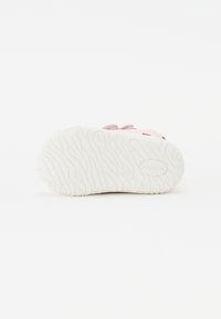 Rosa sneakers med tekstureret hvid gummisål. Har flade snørebånd og et minimalistisk design, der fremhæver de kontrasterende farver og materialer.