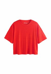 T-shirt rouge à manches courtes avec un col rond. Le tissu présente un motif texturé subtil et il a une coupe ample et décontractée.