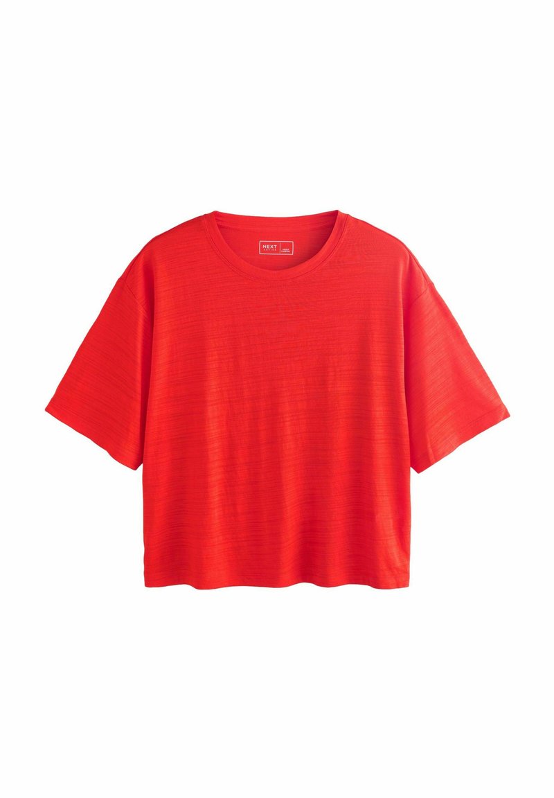 T-shirt rouge à manches courtes avec un col rond. Le tissu présente un motif texturé subtil et il a une coupe ample et décontractée.