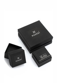 Melnas iepakojuma kastes dažādos izmēros. Matēta tekstūra ar KUZZOI logotipu augšpusē. Ietver etiķeti ar norādi par pārstrādātu materiālu un izcelsmi.