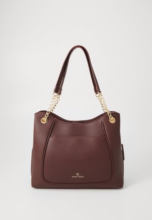 Sac à main en simili cuir bordeaux avec deux poignées, accents en chaîne dorée, surface texturée et détail de poche avant. Logo doré visible.
