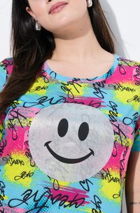 Kleurvol T-shirt met korte mouwen, gekenmerkt door een grote zilveren glimlachende gezicht graphic op een heldere achtergrond met gevarieerde texturen en abstracte patronen.