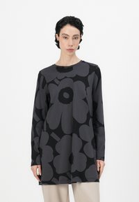 Long-sleeve top in dark gray featuring black oversized floral pattern. Round neckline, relaxed fit, and soft fabric with a smooth texture.