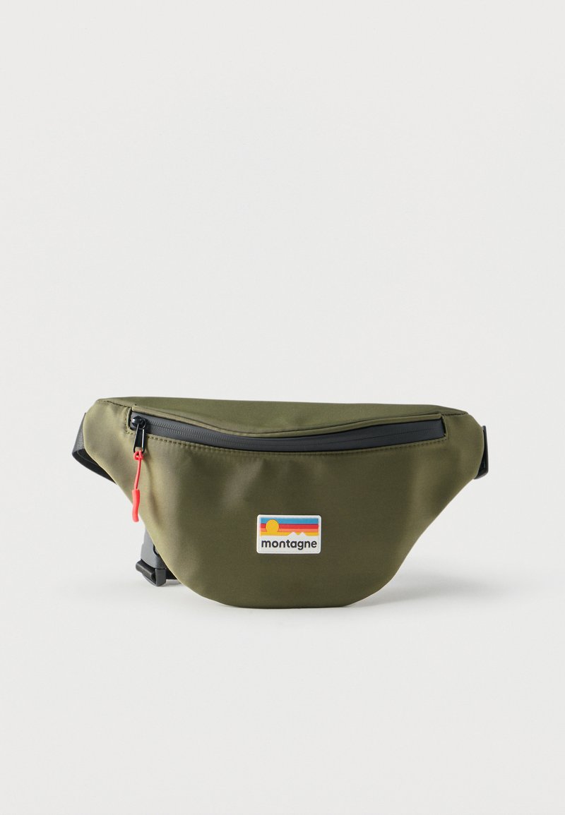 Sac banane vert olive avec fermeture éclair noire et tirette rouge, sangle noire réglable, et patch logo Montagne coloré au centre avant.