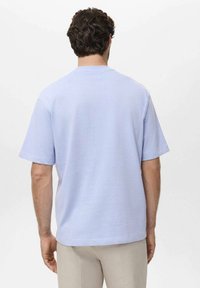 Světle modré tričko s krátkým rukávem vyrobené z bavlny; design s kulatým výstřihem a uvolněným střihem; hladká textura a minimalistický styl.