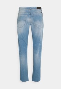 Jeans de mezclilla azul claro con un diseño de pierna recta, que presentan acentos deslavados, dos bolsillos traseros y una etiqueta negra en la cinturilla.