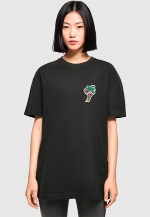 Black t-shirt made of cotton with short sleeves. Features a colorful embroidered motif of a palm tree and ice cream cone on the chest.