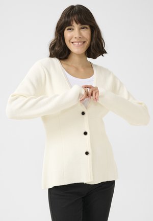 White knitted cardigan with a v-neck, front buttons, and long sleeves. Textured fabric and fitted silhouette.