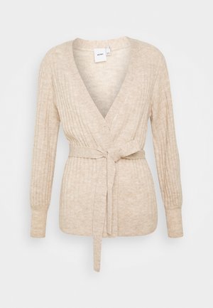 Cardigan cache-cœur en maille côtelée beige avec manches longues et ceinture en tissu nouée à la taille.