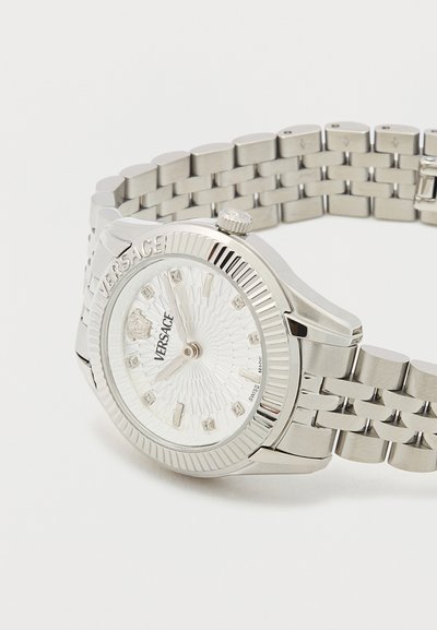 Hõbedane roostevabast terasest kell, millel on tekstuuriga valge sihverplaat, teemantikujulised tundeosutid ja poleeritud raam, millel on linkriba ja kroon.