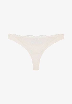 Lace thong in off-white with leaf patterns. Features a delicate scalloped waistband and a smooth fabric texture. Minimalist design.