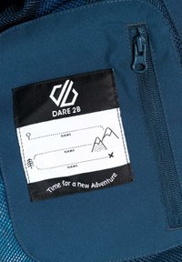 Marineblauer Stoff mit einem schwarzen Etikett, auf dem das "DARE 2B"-Logo zu sehen ist. Ein strukturiertes Design mit Bereichen für Namen und Berggrafiken.
