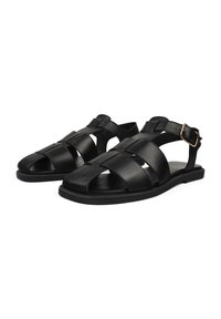 Sandali neri in pelle con design open-toe, multiple cinghie incrociate, fibbia alla caviglia e suola piatta in gomma per il massimo comfort.