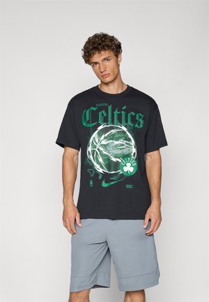 Sort bomulds t-shirt med grøn "Celtics" grafik og basketball design. Bæres med grå træningsshorts, der har en afslappet pasform og korte ærmer.