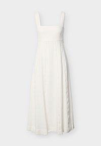 Λευκό αμάνικο μακρύ φόρεμα με τετράγωνο ντεκολτέ και κάθετες διακοσμητικές ραφές, κρεμασμένο σε απλό ανοιχτό φόντο.