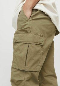 Olivgrüne Cargo-Hosen aus Baumwollmischung mit Seitentaschen, Falten an den Oberschenkeln und gesteppten Details an den Nähten.