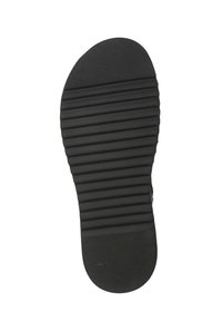 Suola in gomma nera con scanalature orizzontali per trazione, punta arrotondata e superficie liscia, progettata per comfort e stabilità.