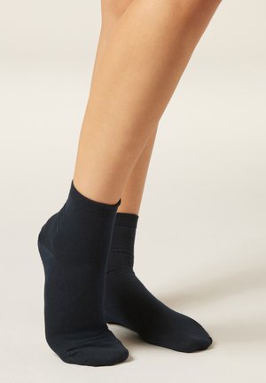 Calcetines tobilleros de algodón azul marino con textura suave, puño acanalado y ajuste ceñido alrededor del tobillo.