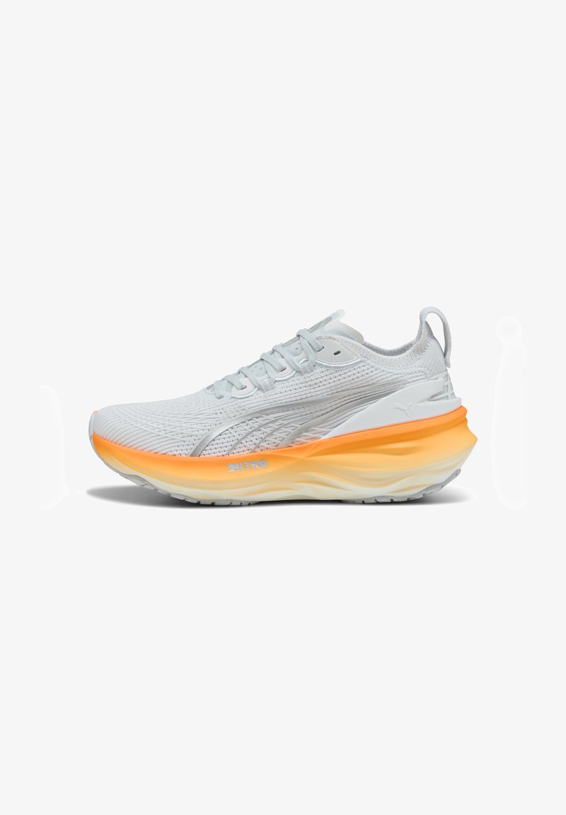 Ljust grå träningsskor med meshtopp, orange-vitt gradient sula, vadderad krage och reflexdetaljer. Lättviktsdesign.