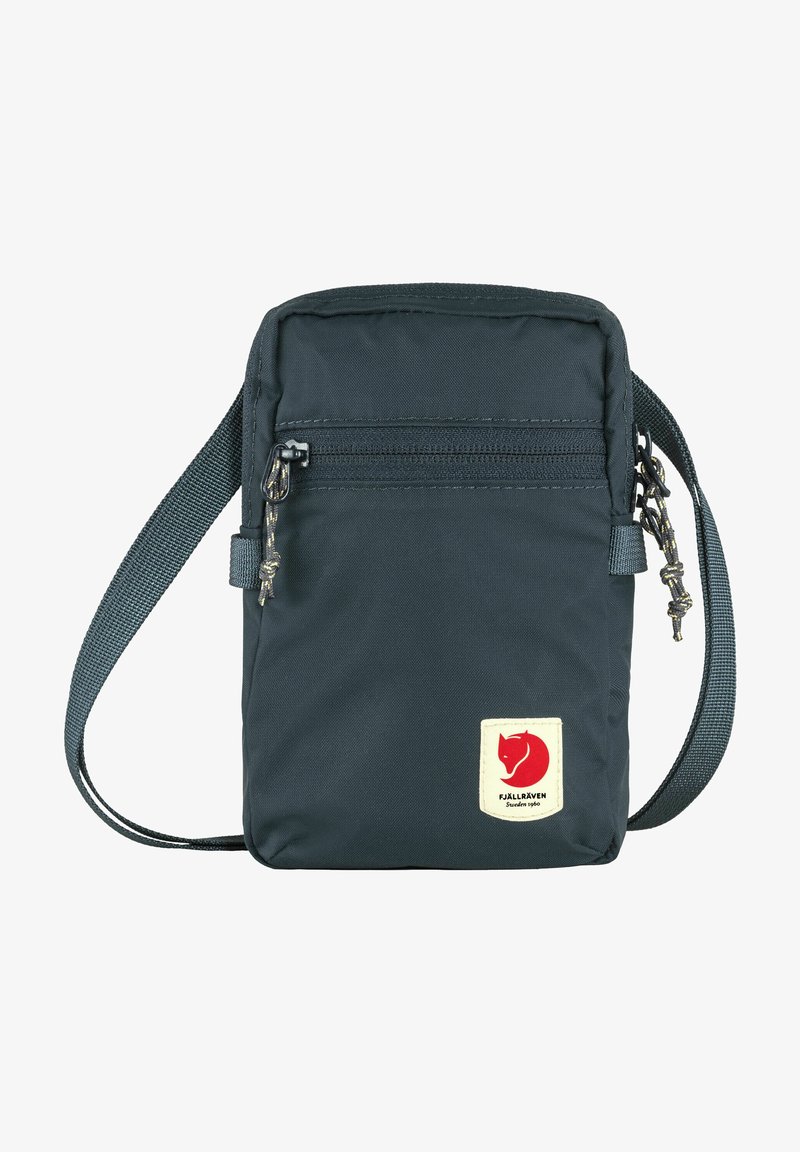 Borsa a tracolla blu scuro realizzata in tessuto resistente, con una tasca anteriore con zip e un'etichetta del logo. Tracolla regolabile per un indossamento confortevole.