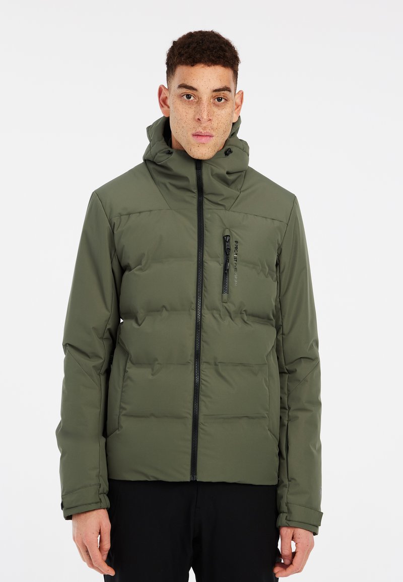 Chaqueta aislante de color verde oliva con cierre de cremallera, cuello alto y diseño acolchado. Presenta un bolsillo en el pecho con cremallera y puños ajustables.