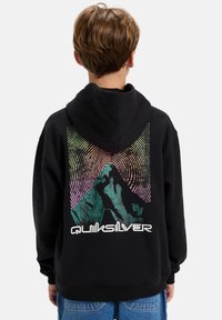 Černá mikina s kapucí s barevným grafickým motivem hory na zádech, obsahující soustředné kruhy a text "Quiksilver" v bílé barvě. Pohodlný materiál, volný střih.