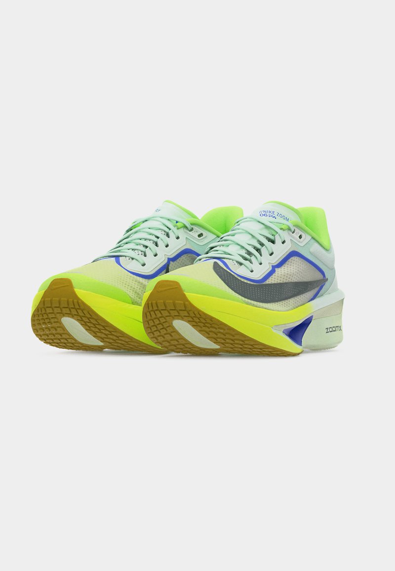 Paire de chaussures de course Nike Zoom vert néon et gris avec des accents citron vert et des semelles texturées marron sur fond blanc.