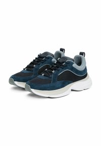 Sneakers da uomo con una tomaia in suede e mesh blu, accenti grigi e una suola in gomma bianca spessa. Presentano lacci neri e un tab sul tallone.