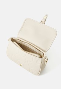 Beige leren handtas met geperste logo-details, gouden hardware en een ritsvak. Magneetsluiting, soepel tekstuur in de binnenkant.