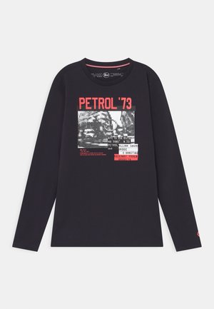 Czarny długi T-shirt z czerwonym napisem "PETROL '73" oraz czarno-białą grafiką panoramy miasta z dodatkowymi napisami z przodu.