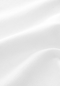 Textured white fabric with a subtle ribbed pattern, gently draped to show soft texture and smooth appearance.