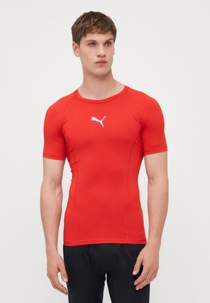 Červené priliehavé športové tričko s krátkymi rukávmi, vyrobené z elastického materiálu. Na hrudi biele logo Puma. Hladká textúra, okrúhly výstrih.