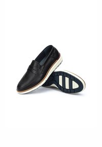 Zapatillas negras de cuero deslizadas con un acabado suave, una entresuela blanca y una suela texturizada en color marino con ranuras horizontales y un acento rojo.