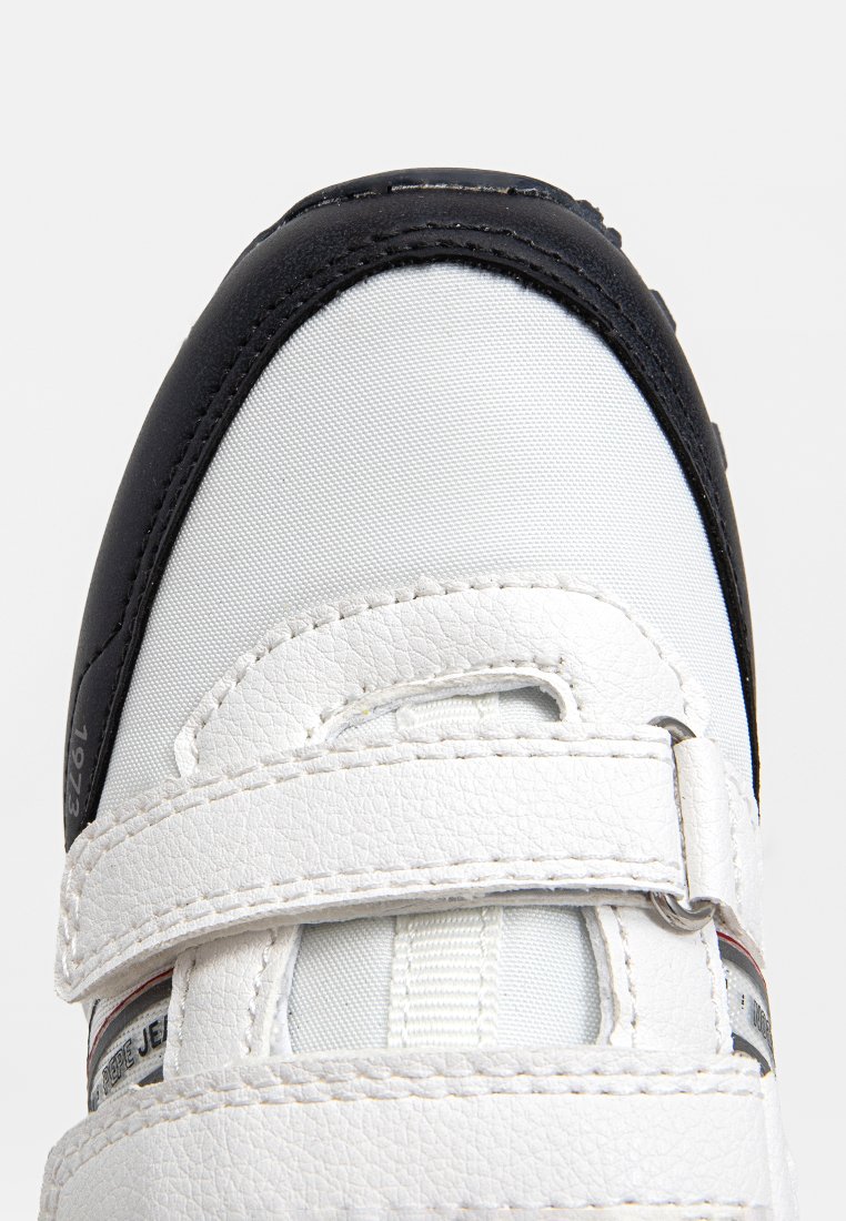 Weißer und schwarzer Sportschuh aus strukturiertem Synthetikleder, mit Klettverschluss, runder Zehenform und dezenten Branding-Details.