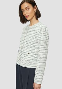 Witte tweed jas met marineblauwe en zwarte strepen, ronde halslijn, zilveren knoopsluitingen en twee voorzakken. Getailleerde pasvorm, textuurstof.