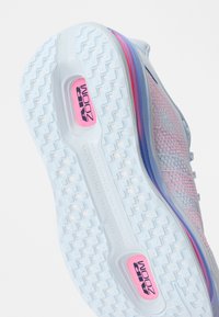 Σόλα λευκού και ροζ παπουτσιού τρεξίματος Nike Air Zoom με ανάγλυφη λαβή και λογότυπο Air Zoom.