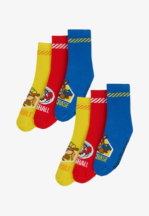 Set aus drei Paaren Kinderstrümpfe: gelb mit Cartoon-Hund, rot mit Pfotenabdruck und blau mit gelben Streifen und Abzeichen-Design. Aus Baumwollmaterial.