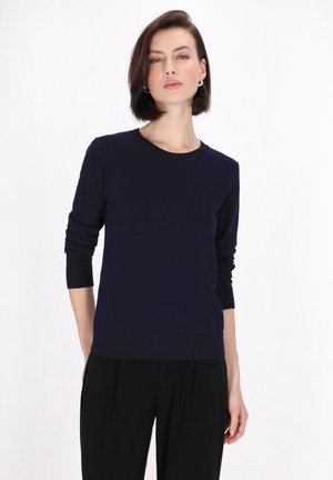 Maglione blu navy a maglia con colletto rotondo, maniche lunghe e polsini e orlo a costine. Texture liscia, silhouette aderente, design minimalista.