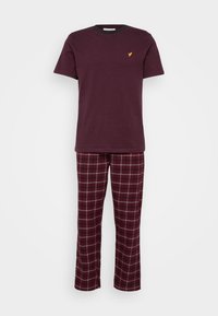 Bordo lühikeste varrukatega T-särk, millel on kollane logo, koos ruuduliste pidžaamapükstega, mis on bordo, valge ja tumeda sinise toonidega. Pehme kangas.