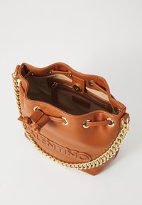 Borsa a secchiello in pelle marrone con tracolla in catena dorata, chiusura con cordoncino, logo impresso e tasca interna con zip.