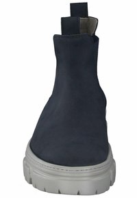 Laivastonsininen nilkkuri, jossa on sileä nahkapinta, joustavat sivut ja paksu valkoinen kumipohja. Pyöreä kärki, jossa minimaalinen ompeludetalji.