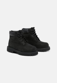 Bottines noires en daim, avec fermeture lacée, col rembourré et semelle en caoutchouc robuste avec un motif texturé pour une meilleure adhérence.