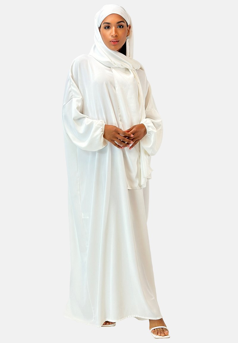 Hvid, flydende abaya lavet af letvægtsstof med lange, puffede ærmer. Følger med en matchende hijab, som har et enkelt design.