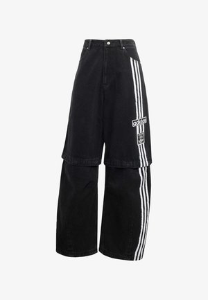 Pantaloni a gamba larga in denim nero con design a strati, caratterizzati da accenti delle tre strisce bianche Adidas e un'etichetta con logo sulla parte anteriore.