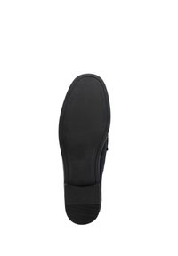 Semelle en caoutchouc noir d'une chaussure, design plat avec des rainures texturées pour l'adhérence, bords arrondis et finition soignée, mettant en avant la durabilité et la stabilité.