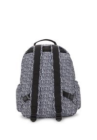 Bakvy av en svart och vit mönstrad ryggsäck med två justerbara axelremmar och ett handtag på toppen.