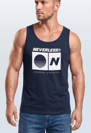 Muskelöser Mann trägt ein dunkelblaues Tanktop mit weißem "NEVERLESS"-Logo, rundem Grafikmotiv und dem Schriftzug "EVERYDAY ATHLETICS", kombiniert mit blauen Jeans.