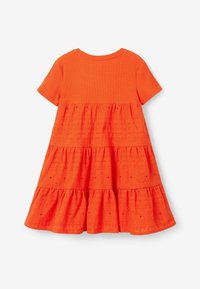 Oranžové krátké šaty s žebrovaným topem a vrstvenou sukní; texturovaná látka s děrovanými detaily a volánky na lemu.